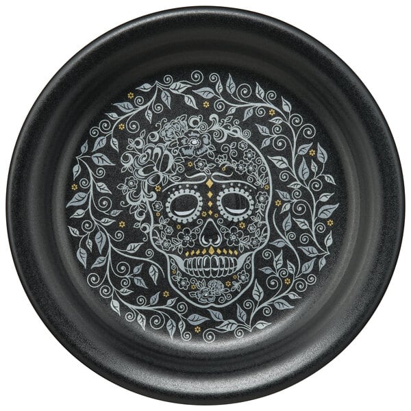 A black plate with a skull and vine design.