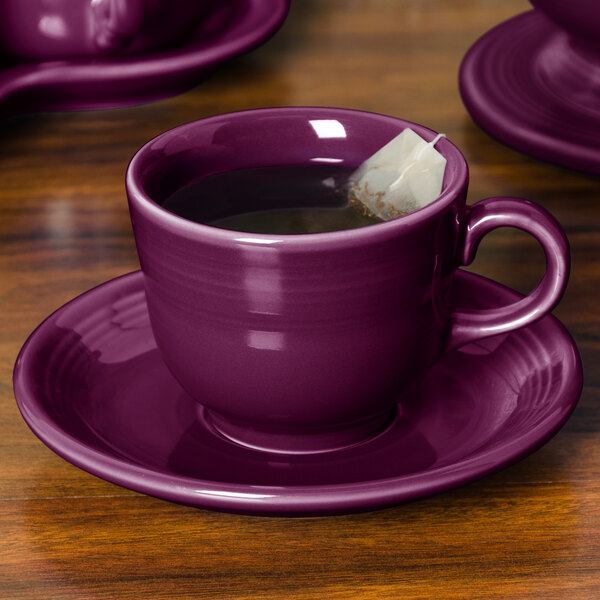 A purple Fiesta china saucer with a tea bag on it.