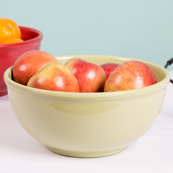 A sage Cal-Mil melamine bowl filled with red and yellow apples.