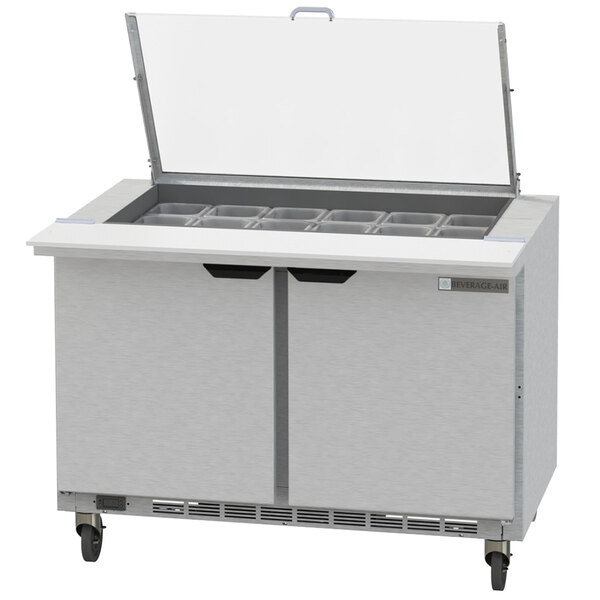 A Beverage-Air stainless steel commercial sandwich prep table with two drawers and a clear lid open.