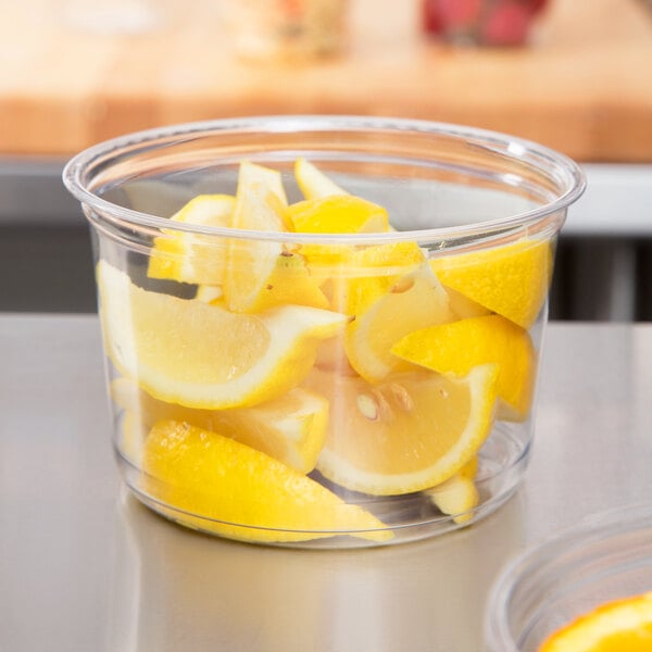 A Fabri-Kal clear plastic deli container with lemons inside.