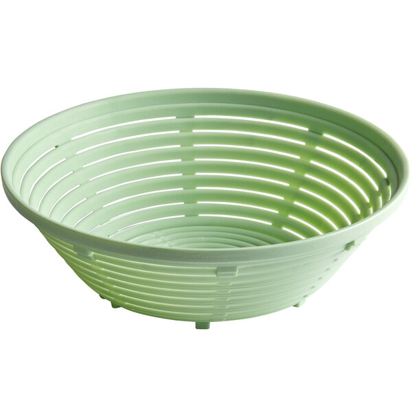 A close up of a green plastic round bread proofing basket with holes.