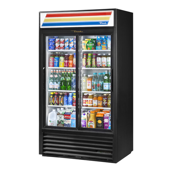 A black True refrigerated glass door merchandiser full of drinks and beverages.