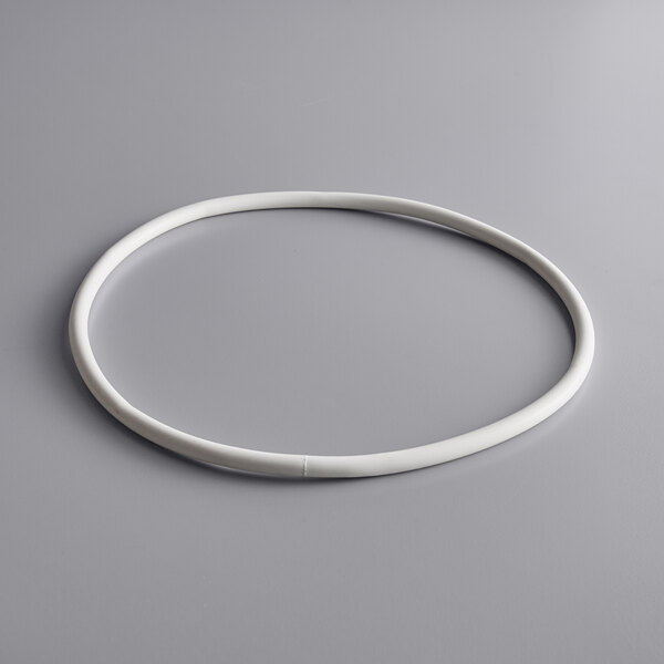 A white plastic gasket with a white hoop on a gray surface.