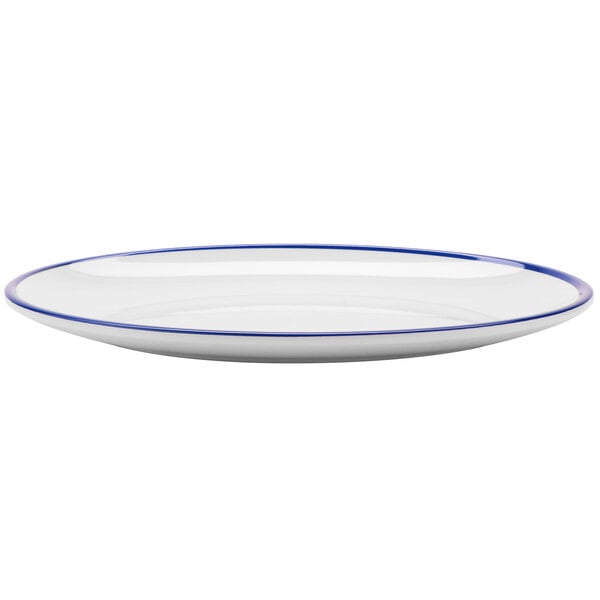 A close up of a GET Settlement Bistro white melamine dinner coupe plate with a cobalt blue rim.