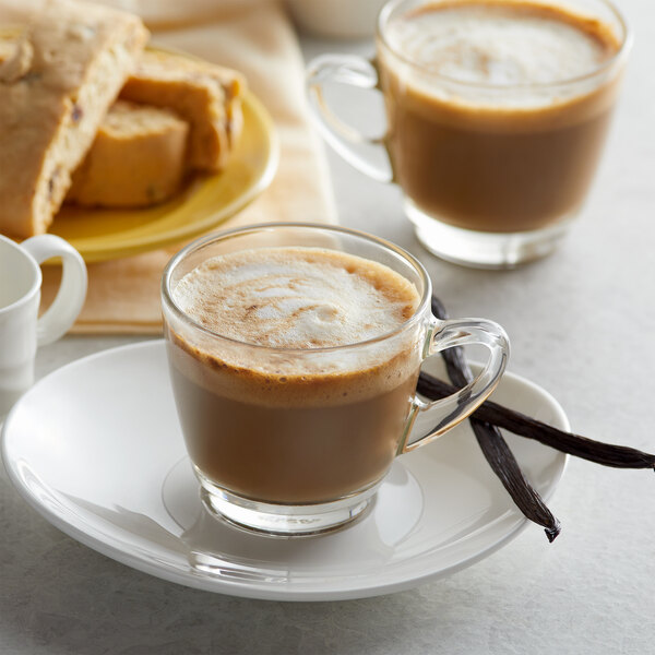 A white mug of UPOURIA Sugar Free French Vanilla Cappuccino on a white plate.