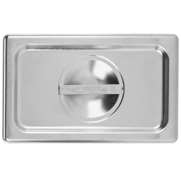 A Vollrath stainless steel steam table pan cover on a metal tray.