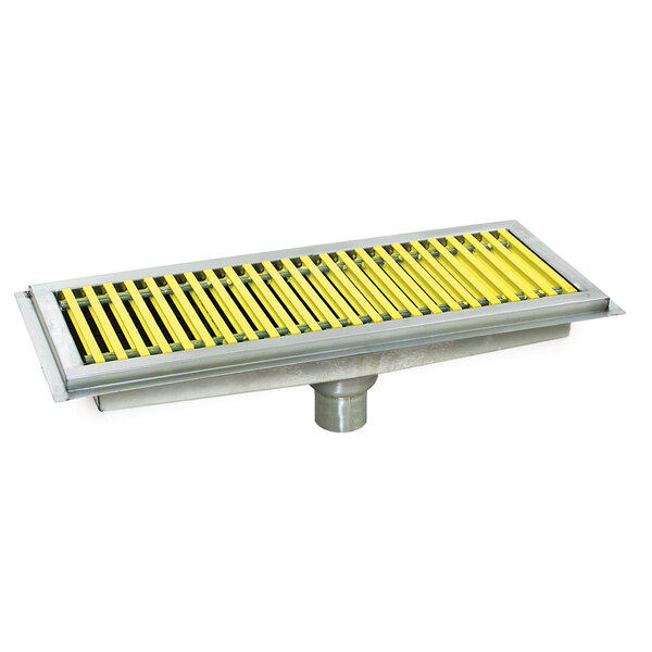 A metal floor trough with yellow fiberglass grating over a pipe.