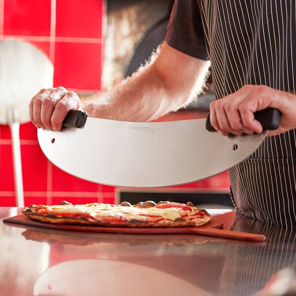 A person using a Dexter-Russell stainless steel pizza rocker to cut a pizza.