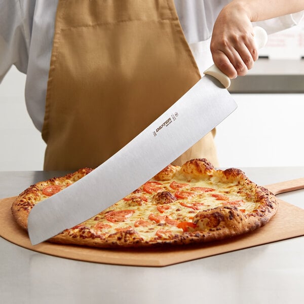A person using a Dexter-Russell Sani-Safe pizza knife to cut a pizza.