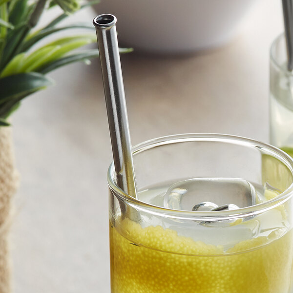 A glass of yellow lemonade with a Barfly stainless steel straw in it.