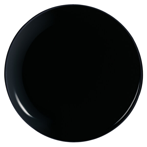 A close-up of a black Arcoroc pizza plate.
