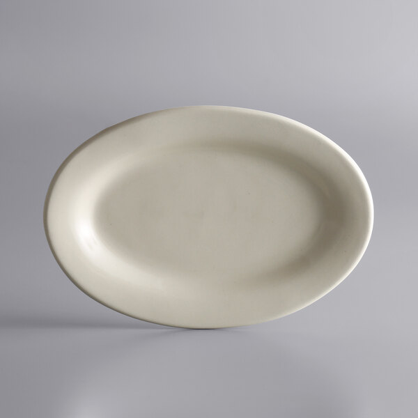 A white Libbey oval stoneware platter with a rolled edge on a gray surface.