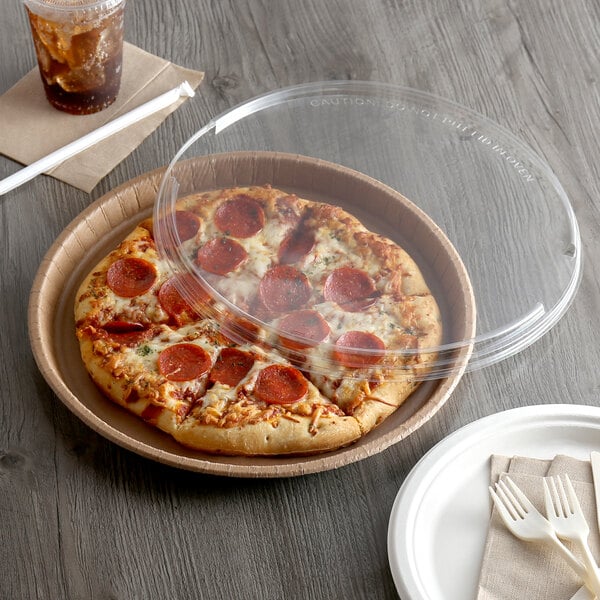 A pepperoni pizza in a Solut cardboard container with a plastic lid.
