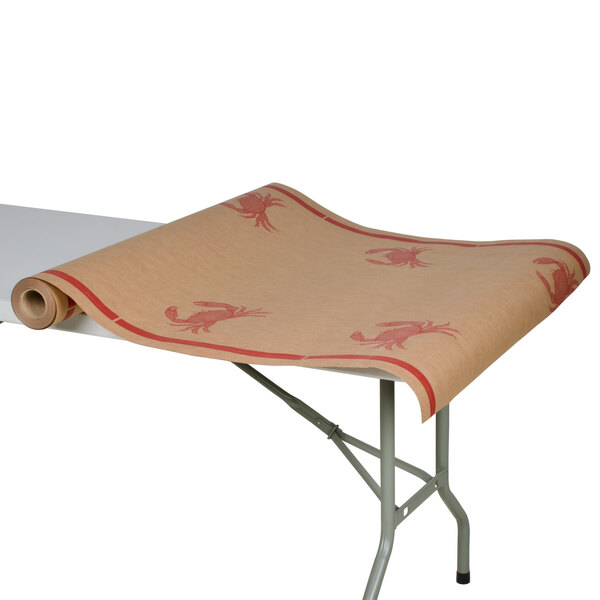 A table with a roll of brown paper with crab designs on it.