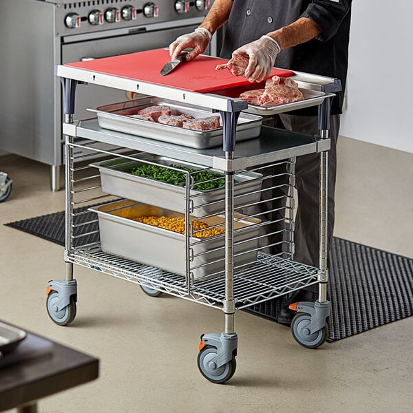 A chef prepares food on a Metro Prepmate Multistation cart in a professional kitchen.
