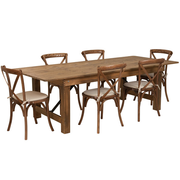 A Flash Furniture rustic wooden farm table with chairs and white cushions.