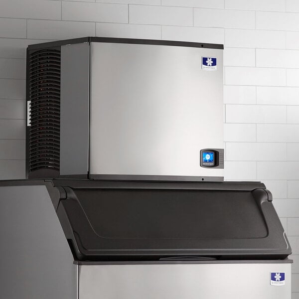 A large silver and black Manitowoc Indigo NXT air cooled ice machine.