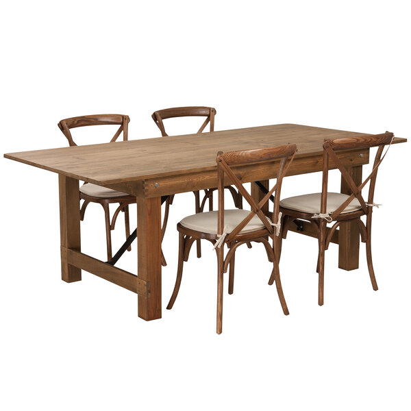 A Flash Furniture rustic wooden farm table with four chairs with white cushions.