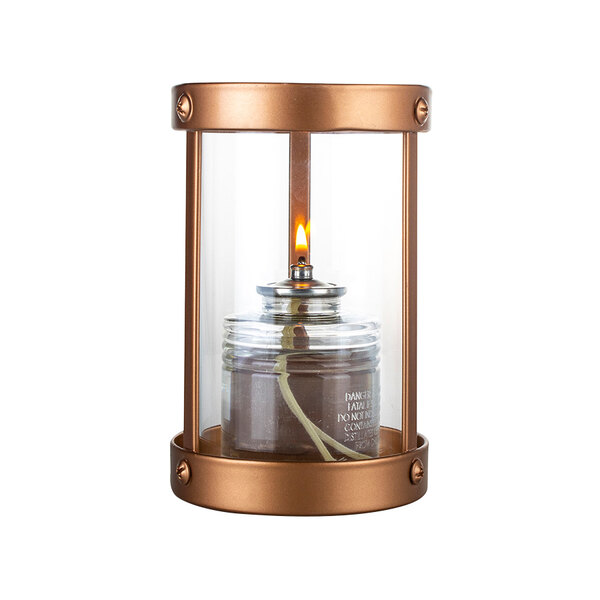 A Sterno copper and glass votive candle holder with a lit candle inside.