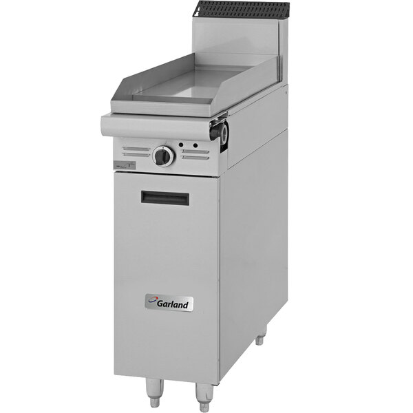 A Garland natural gas griddle range attachment with storage on a stainless steel counter.