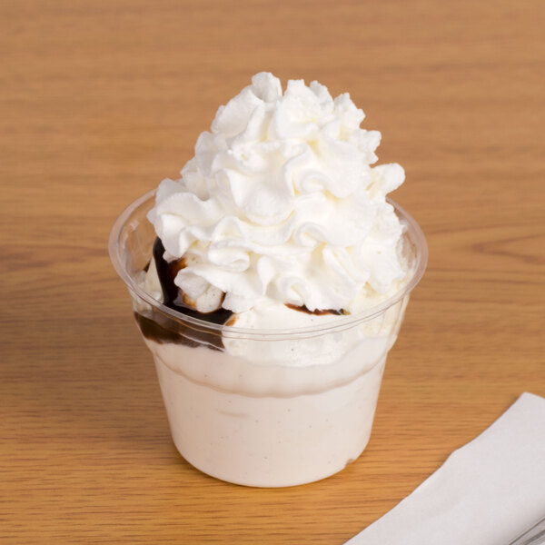 A WNA Comet Classic Dessert Specialty Cup filled with ice cream and whipped cream.