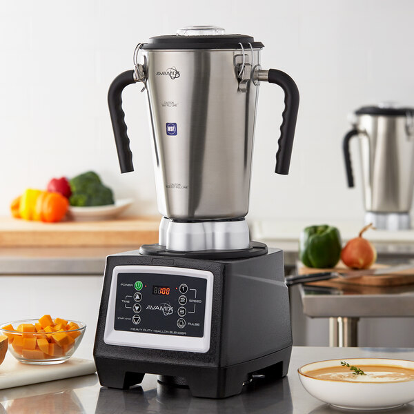 A AvaMix stainless steel commercial food blender on a counter with bowls of vegetables.