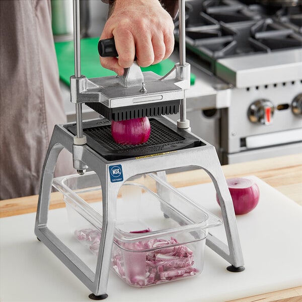 A person using a Vollrath 1/4" Dicer Assembly to cut a red onion.