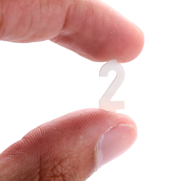 A person holding a white 2 deli tag insert with a finger