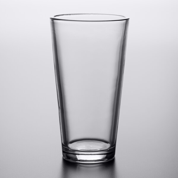 An Arcoroc clear tempered mixing glass on a table.