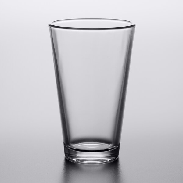An Arcoroc mixing glass on a white surface.