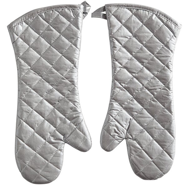 A pair of white oven mitts with silver quilted design.