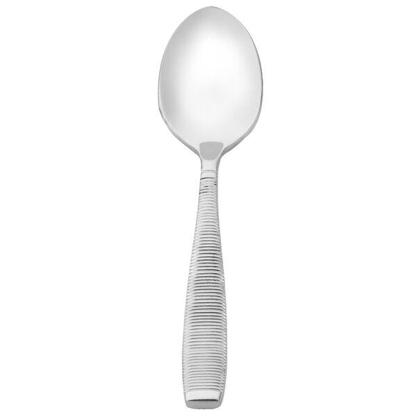 A close-up of a Walco stainless steel demitasse spoon with a white handle.
