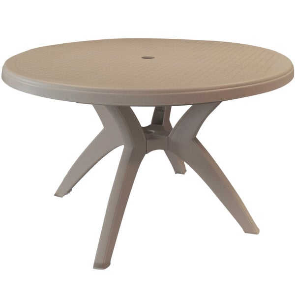 A Grosfillex Ibiza round taupe plastic pedestal table with an umbrella hole.