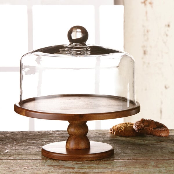 An American Atelier wood cake stand with glass dome cover on a wooden base.