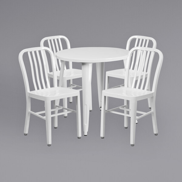 A Flash Furniture white metal round table with four white chairs.