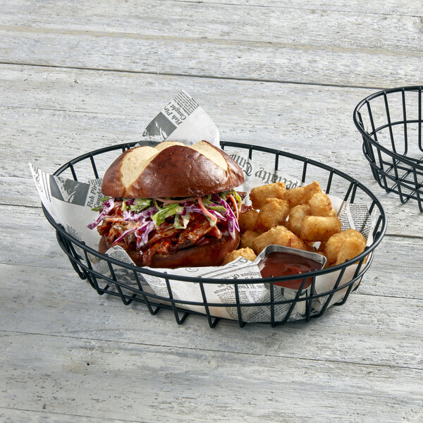 An American Metalcraft black metal wire basket with a sandwich and tater tots in it.