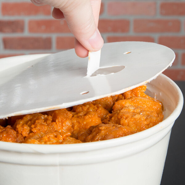 A hand using a Solo paper lid to cover a white food bucket.
