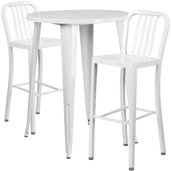 A white metal bar table with two white bar stools with vertical slat backs.