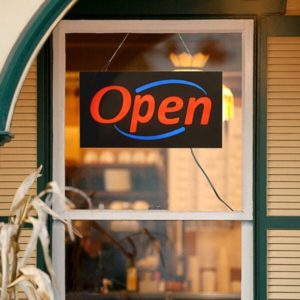 A white rectangular LED sign that says "Open" in blue and red text.