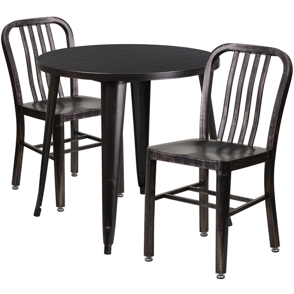 A Flash Furniture black metal table with antique gold accents and two black metal chairs with vertical slat backs.