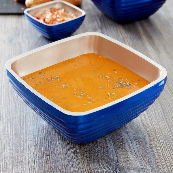A cobalt blue Vollrath double wall metal serving bowl with food in it.