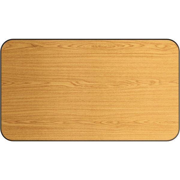 A Lancaster Table & Seating rectangular wood table top with a wood surface and black edges.