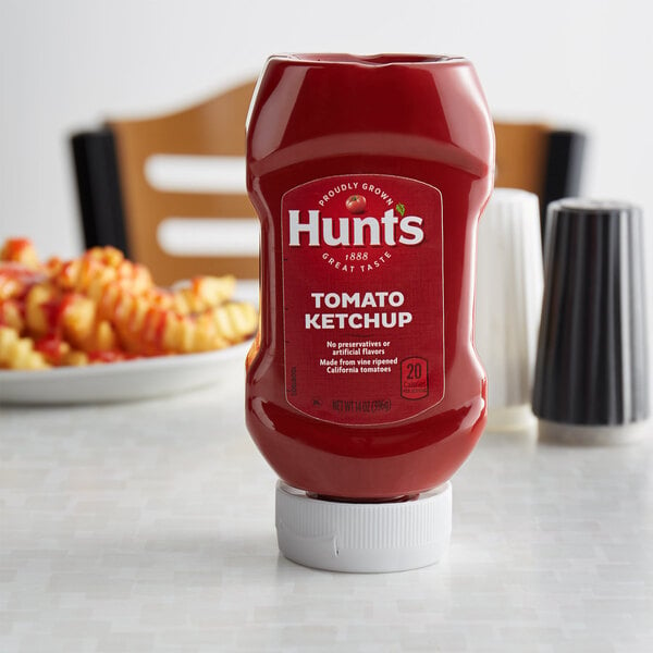 A squeeze bottle of Hunts tomato ketchup on a table.