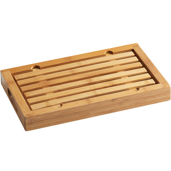 A wooden rectangular Cal-Mil crumb catcher cutting board with a handle.