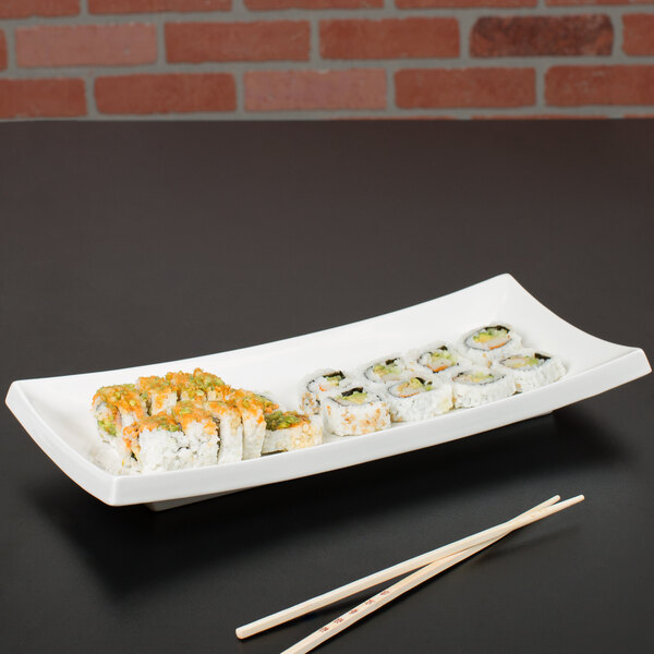 A CAC Tokyia bone white rectangular porcelain platter with sushi and chopsticks.