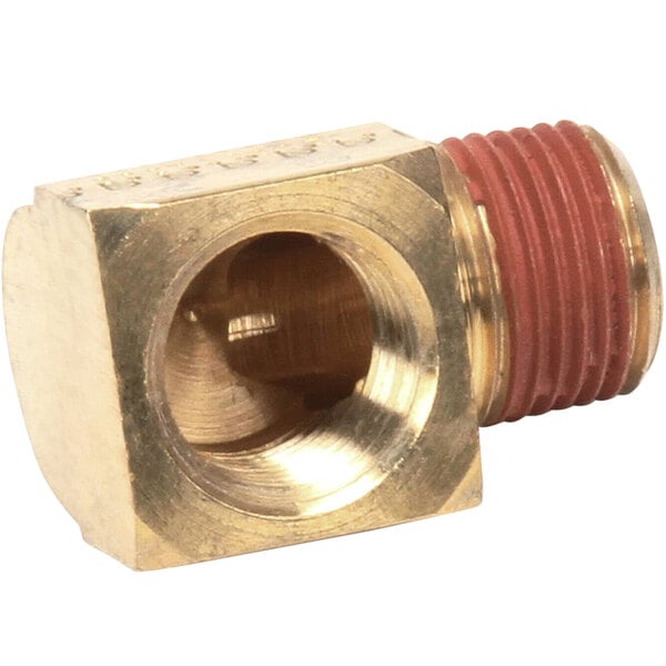 A close-up of a brass Cleveland street elbow threaded pipe fitting with a red nut.