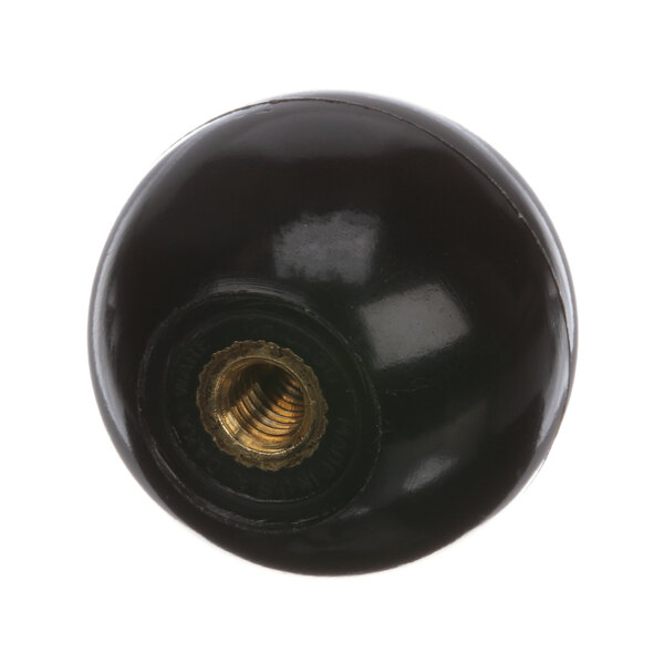 A black round knob with a gold nut on it.