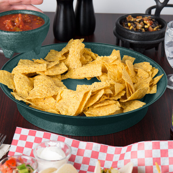 A table with a bowl of chips and salsa served in a black HS Inc. round deli server.