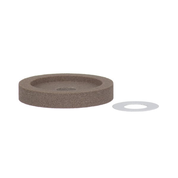 A brown ceramic Hobart grinding wheel with a hole and a ring.